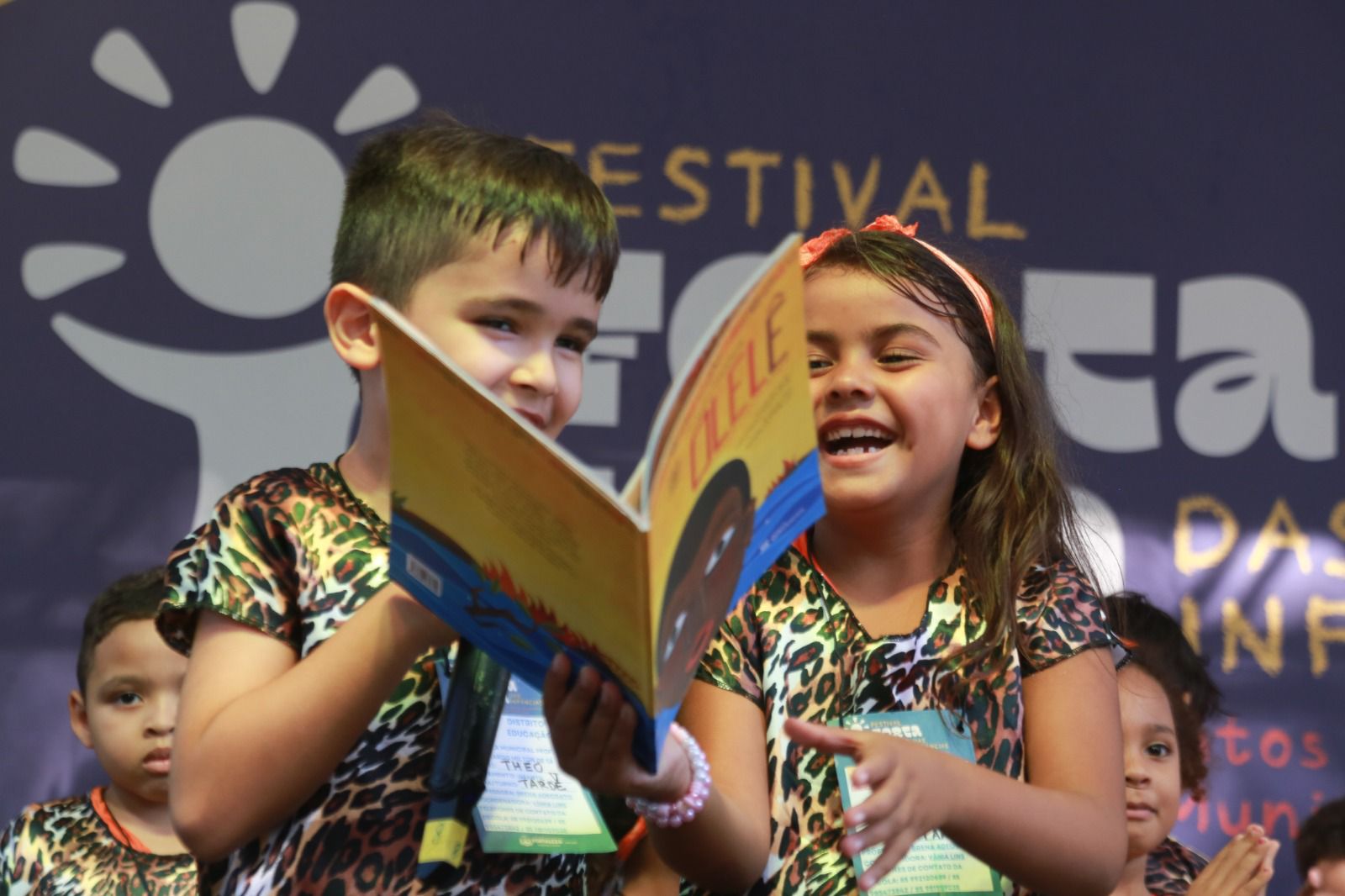 duas crianças segurando um livro